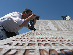 A journalist photographs the names of victims